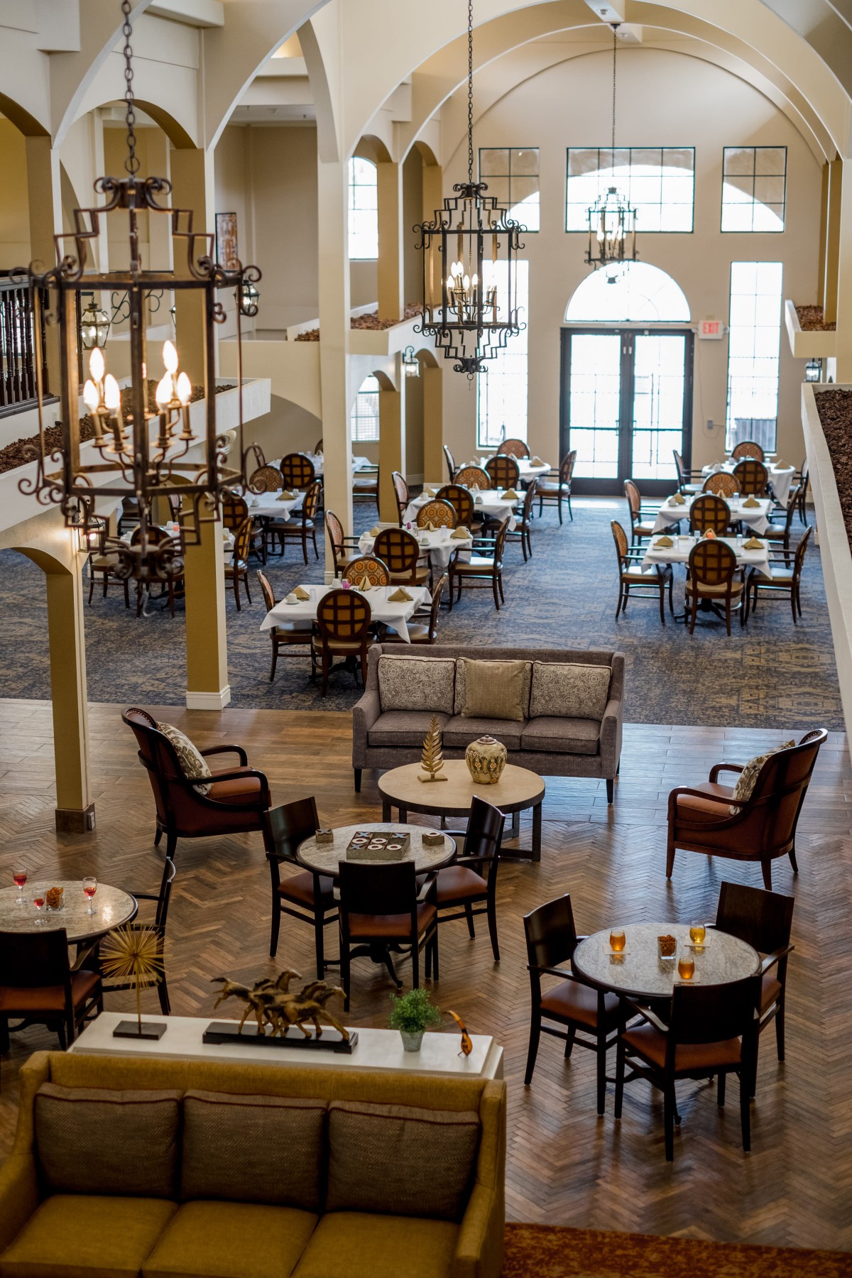A spacious dining and lounge area with elegant chandeliers and comfortable seating.