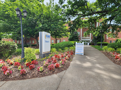 A welcoming entrance with colorful flowers leading to a building.