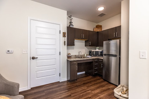 A modern kitchen featuring sleek cabinetry, stainless steel appliances, and a warm wooden floor.