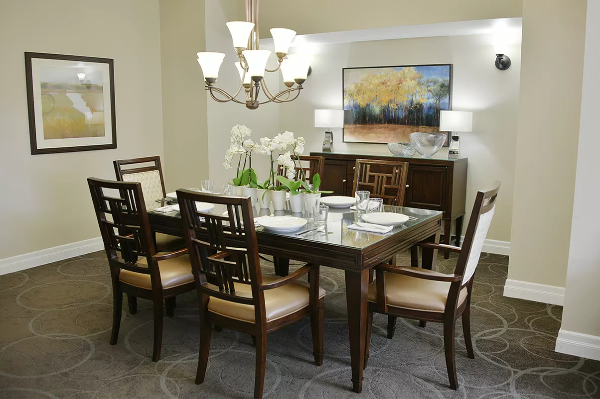 A modern dining room with elegant furniture and a stylish chandelier.