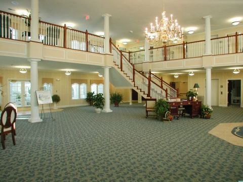 An elegant lobby with a grand staircase and chandelier.