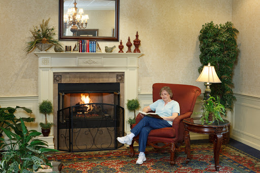 A person enjoying a quiet moment reading in a cozy living room next to a warm fireplace.