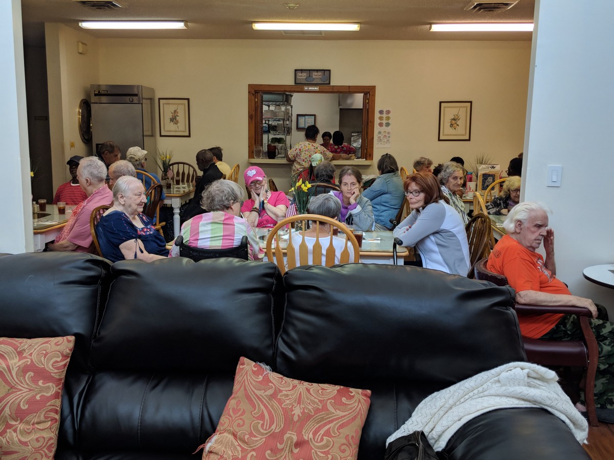 A group of people gathered in a dining area, enjoying a social event.