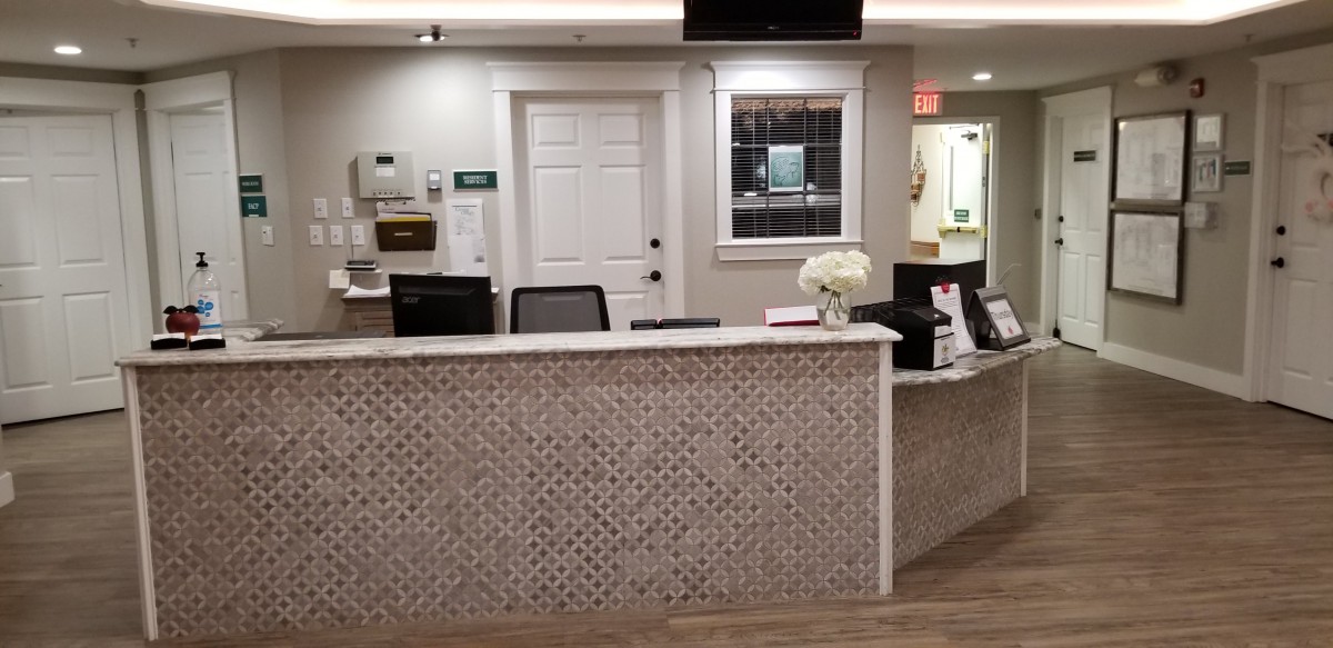 A welcoming reception desk in an office setting with a floral arrangement.