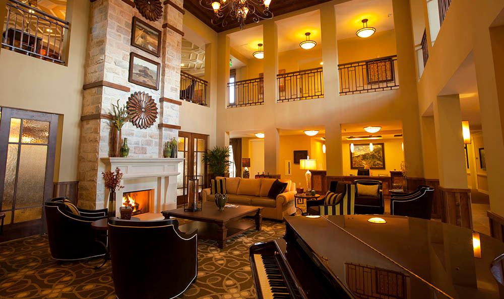 A luxurious hotel lobby featuring elegant furniture, a cozy fireplace, and a grand piano.