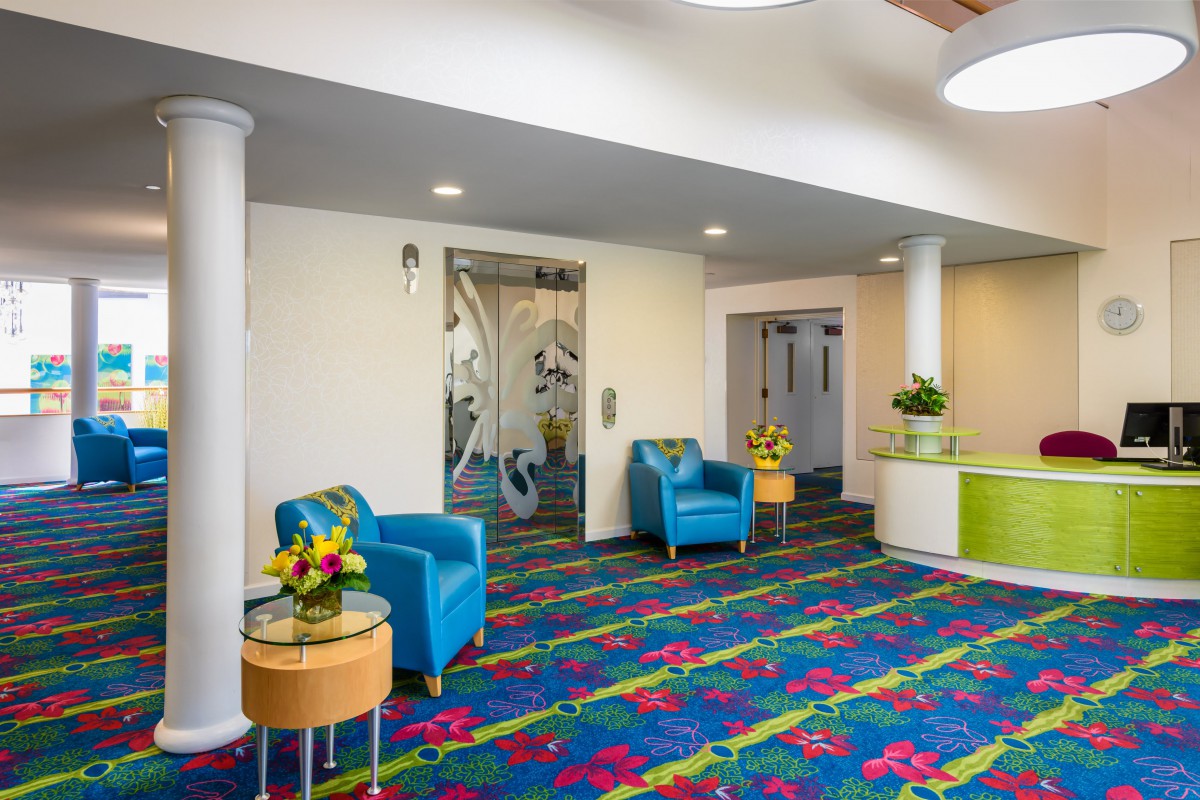 A vibrant and modern lobby area featuring colorful carpet and seating arrangements.