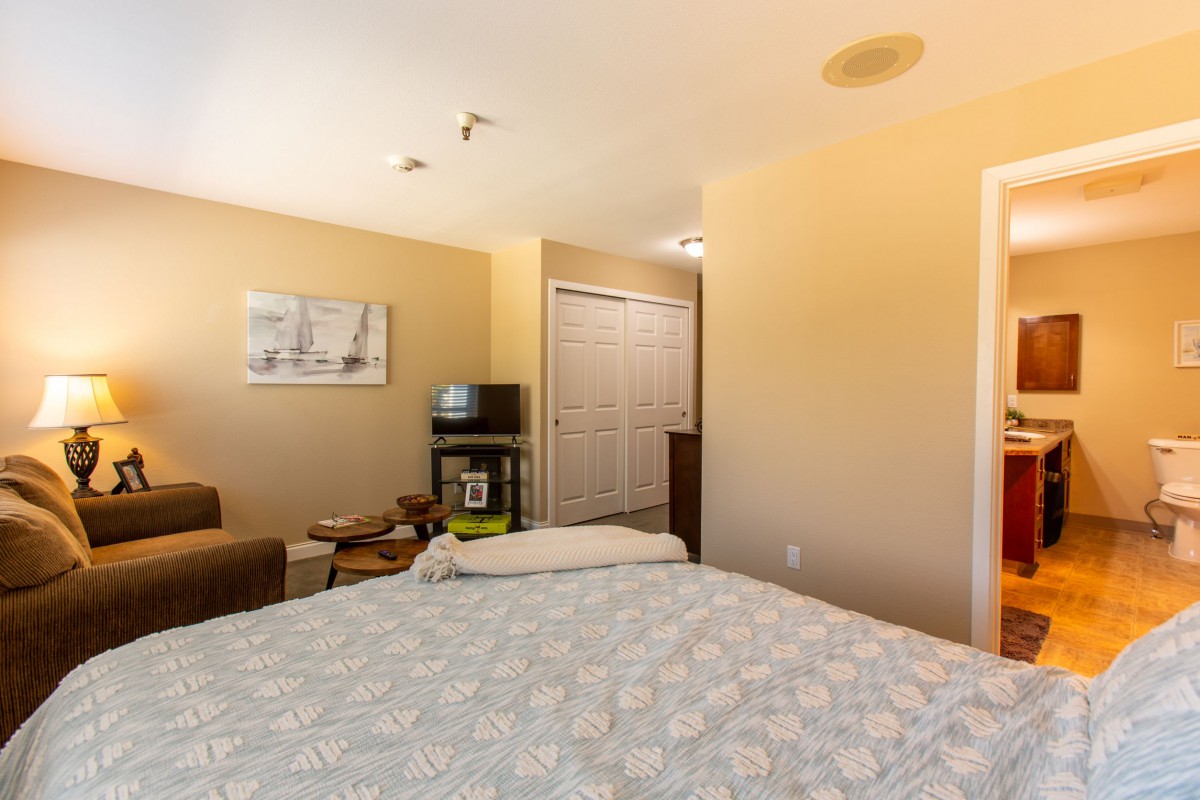A cozy bedroom with a bed, television, and closet space.