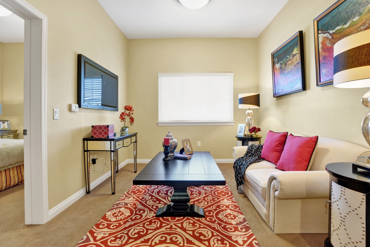 A modern living room with colorful accents, featuring a comfortable sofa, coffee table, and decorative wall art.