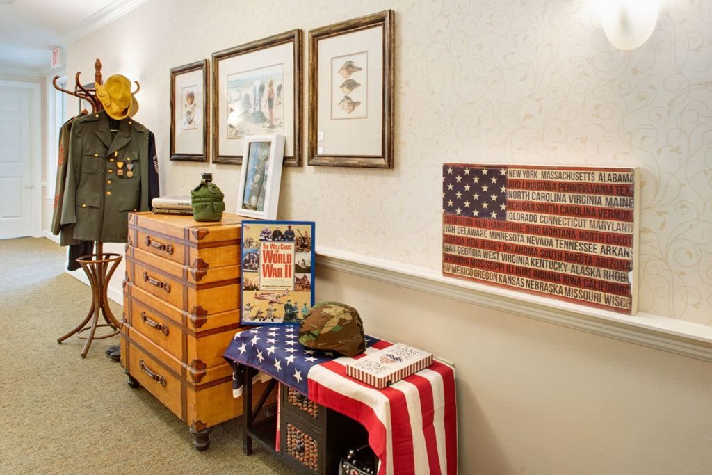 A display featuring vintage military memorabilia, including a uniform, helmet, and American flag decor.
