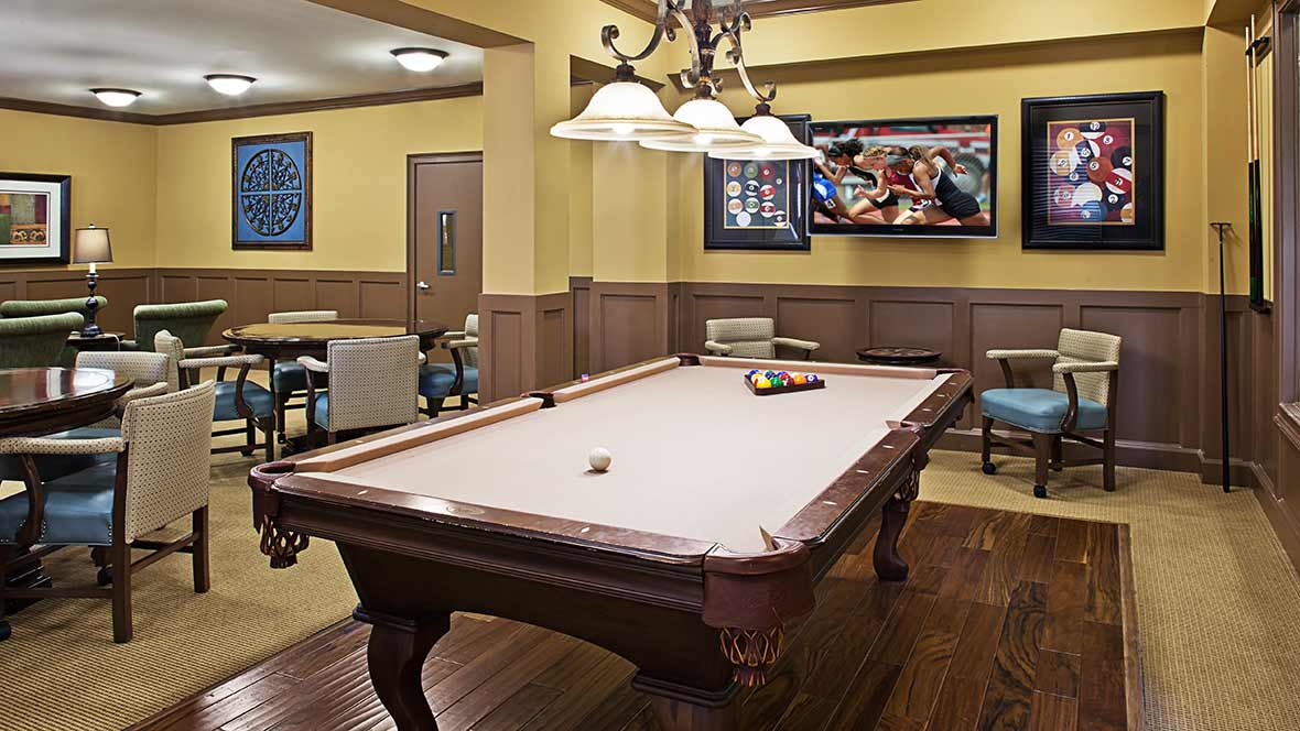 A cozy game room with a pool table and overhead lighting.