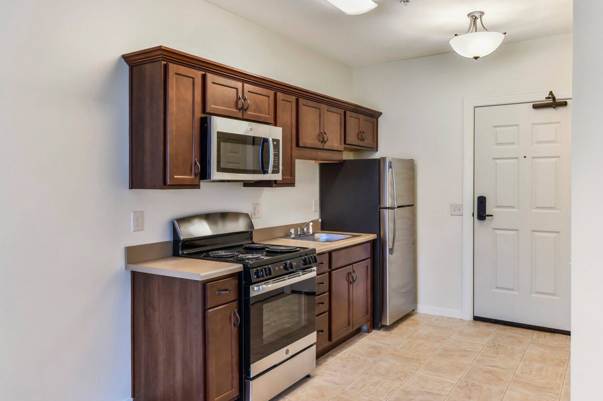 Modern kitchen with wooden cabinets and stainless steel appliances.