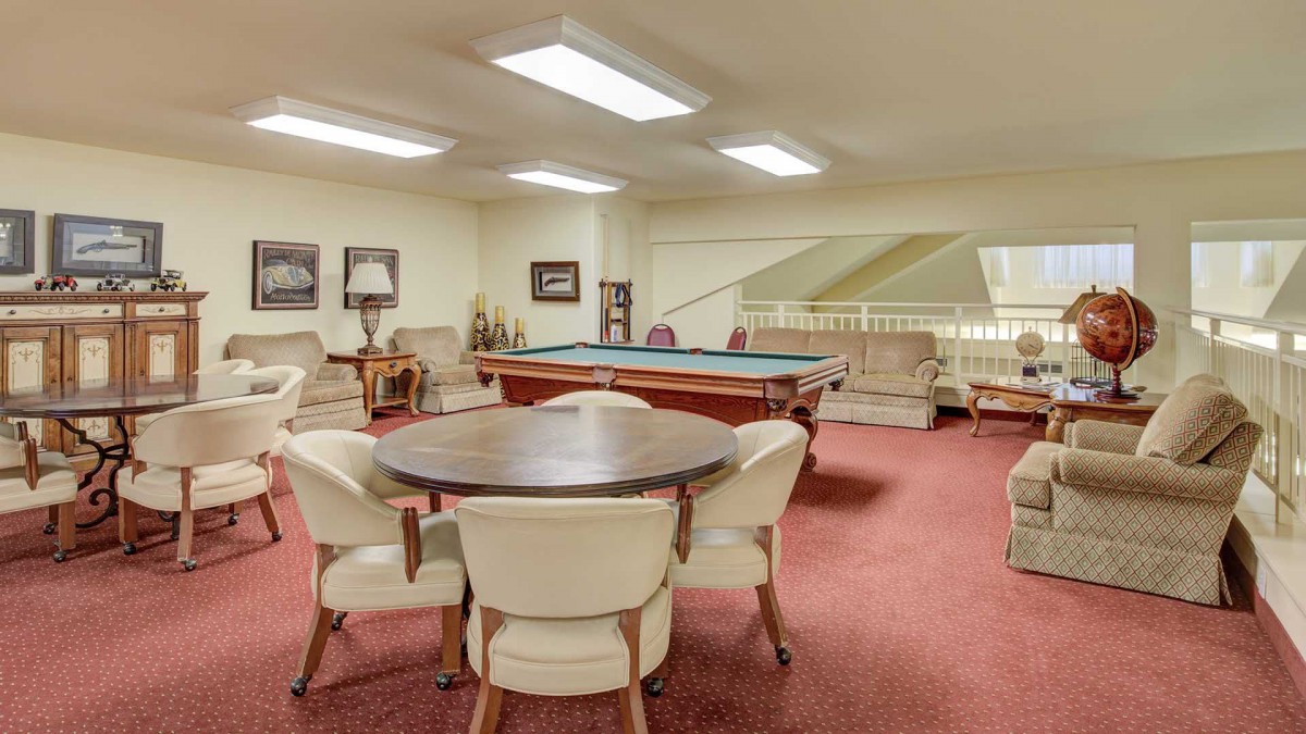 A cozy game room featuring a billiards table and comfortable seating options.