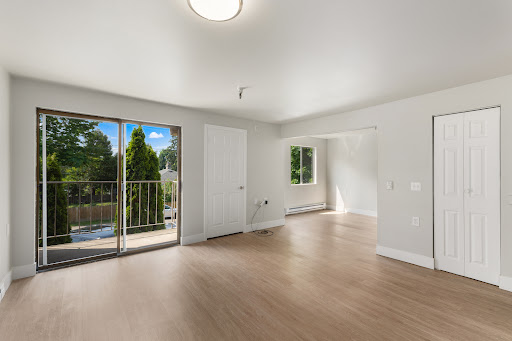 A bright and modern living room featuring a spacious layout with access to a balcony.