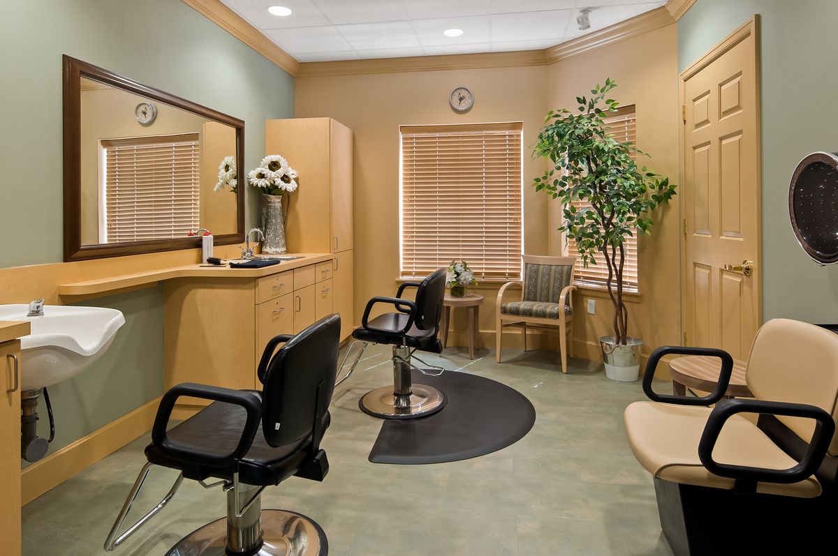 A cozy salon interior with styling chairs, mirrors, and a waiting area.