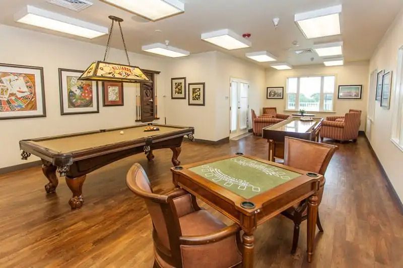 A cozy game room with a pool table and card table, designed for leisure activities.