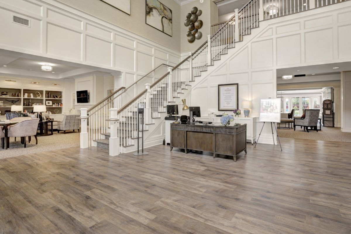 A modern lobby with a grand staircase and wood flooring.