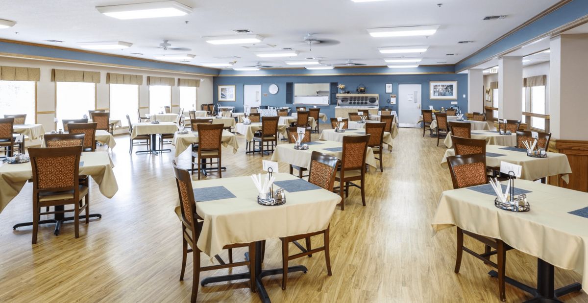 An empty dining room with neatly arranged tables and chairs.