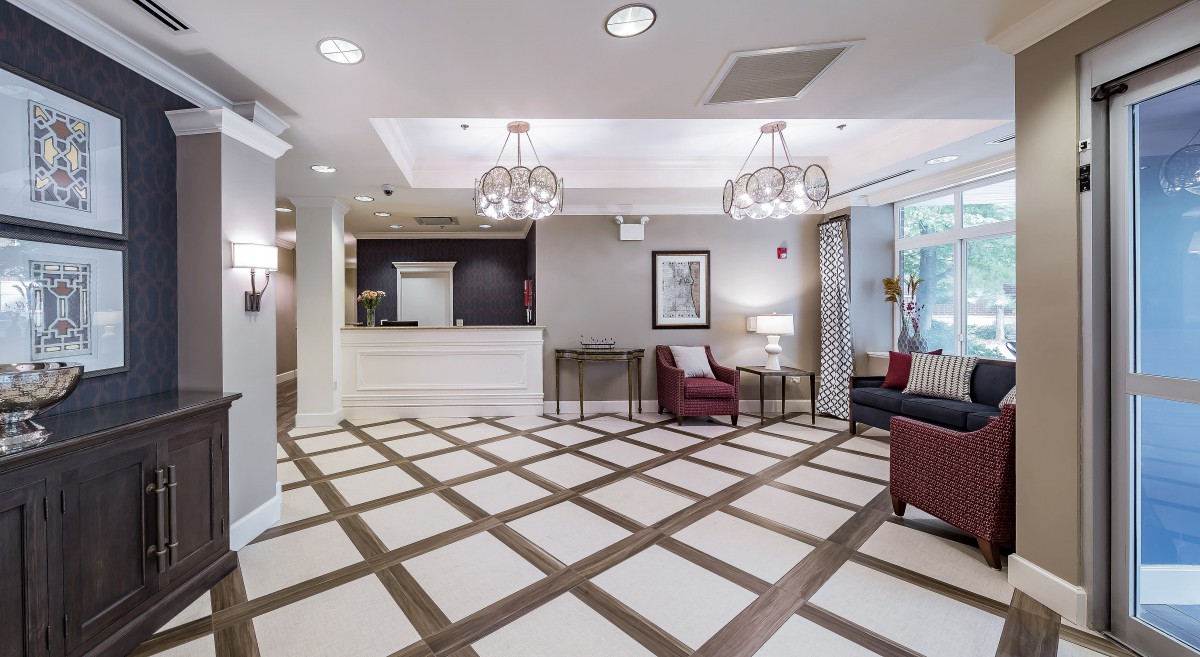 A modern hotel lobby with a reception desk, comfortable seating, and stylish lighting.