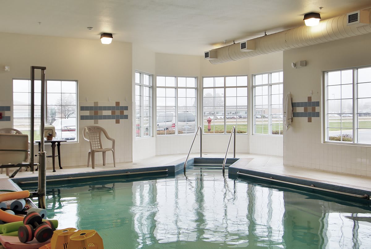 An indoor swimming pool surrounded by large windows, offering a relaxing environment.