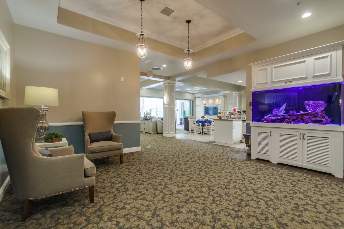 A spacious and well-lit lobby area featuring comfortable seating, an aquarium, and elegant decor.
