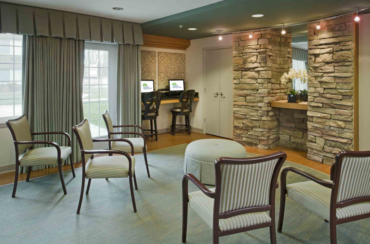 A cozy waiting area with seating, computers, and a stone-accented wall.