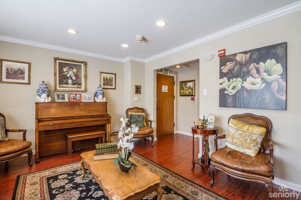 A cozy living room with traditional decor, featuring a piano and elegant furnishings.