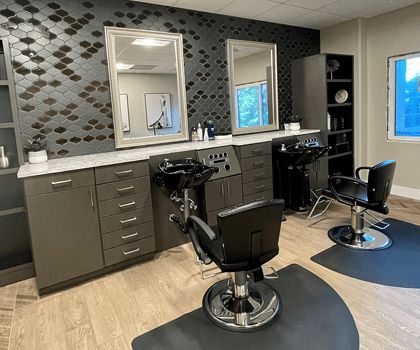 A sleek and modern salon interior with styling stations and barber chairs.