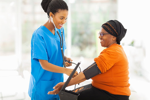 A nurse checks the blood pressure of a patient during a medical examination in a healthcare setting.