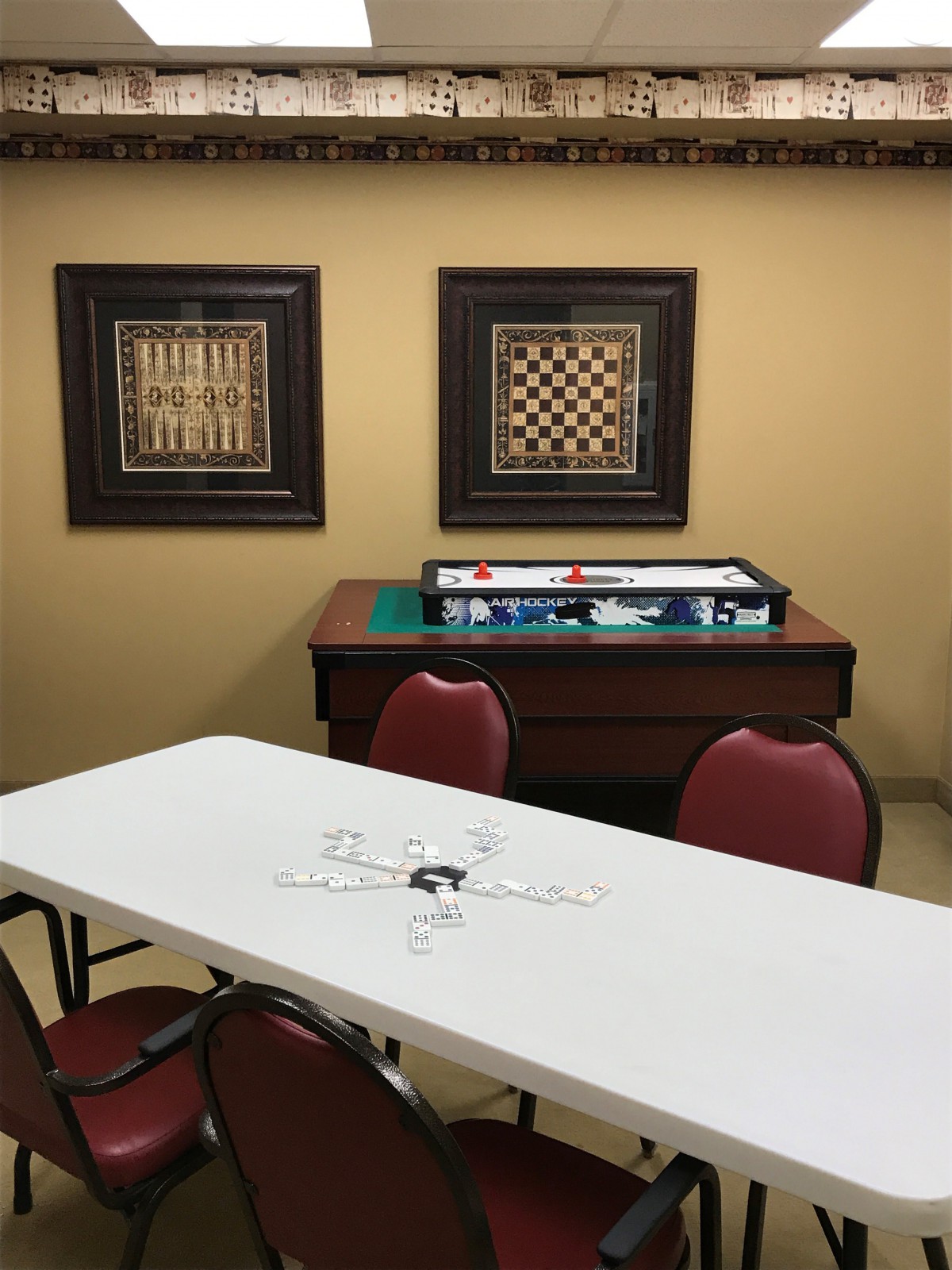 A game room featuring a chess board, framed artwork, and seating arrangement.