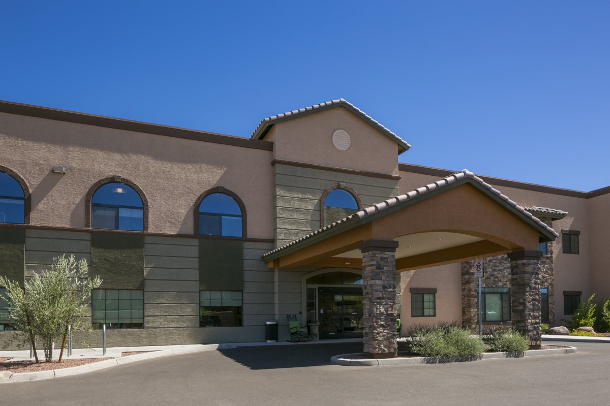 A modern hotel building with a welcoming entrance and large arched windows.