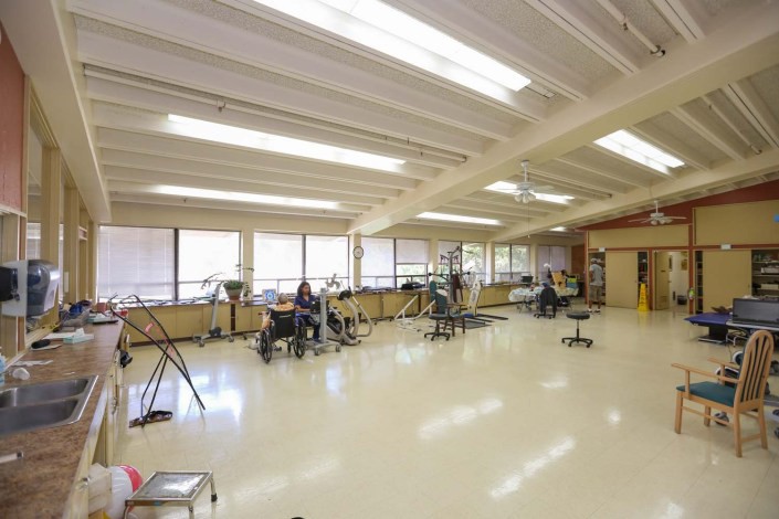 A spacious gym with fitness equipment and large mirrors.