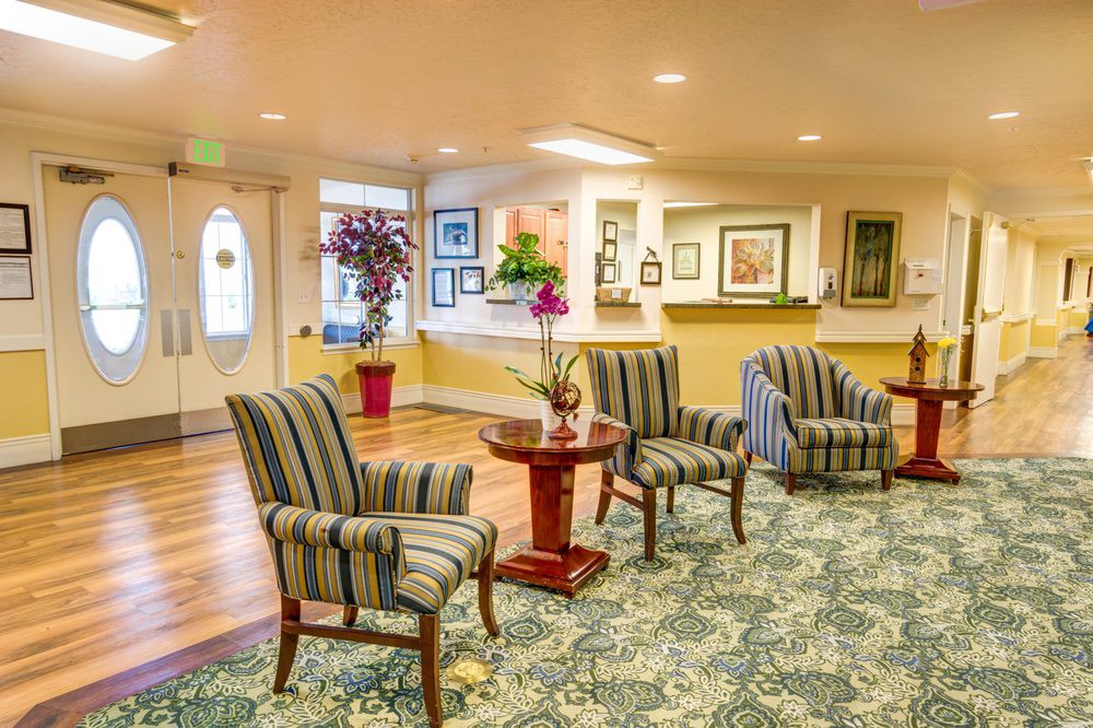 A well-decorated lobby area with striped chairs, a small table, and various decorative elements.