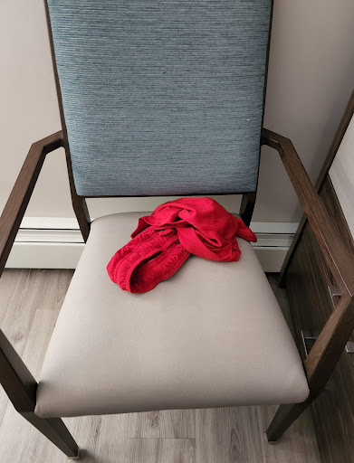 A red cloth draped over a minimalist chair.