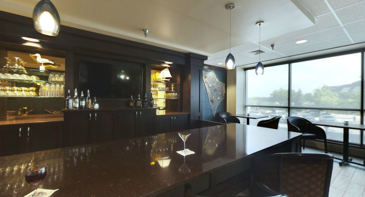 A modern bar interior with a sleek countertop and ambient lighting.