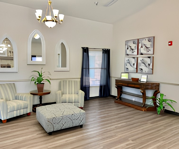 A cozy living room with elegant furnishings and decor, featuring a chandelier, wall art, and potted plants.