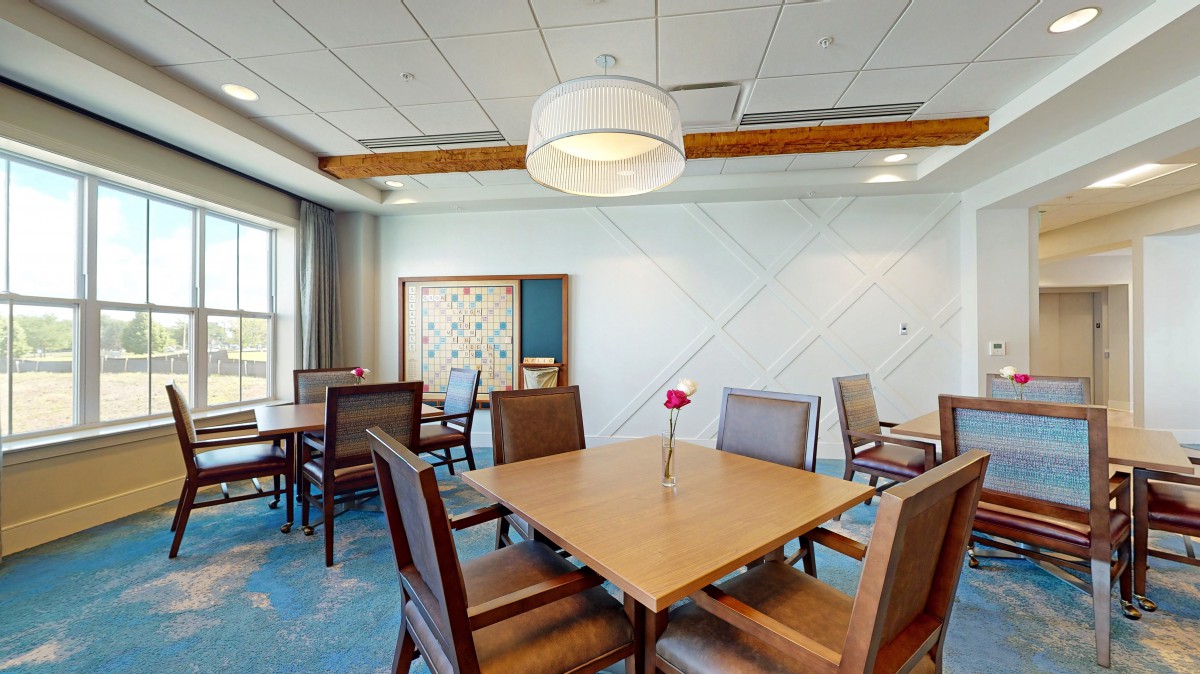 A modern dining room with a wooden table, chairs, and contemporary lighting.