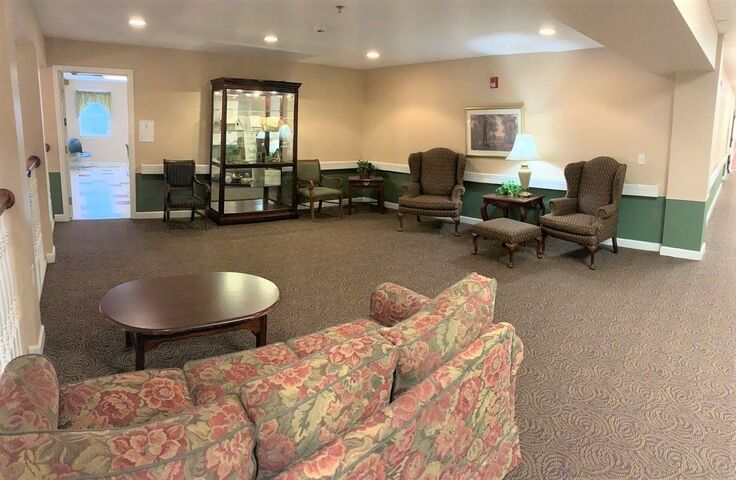 A cozy living room with comfortable seating and a display cabinet.