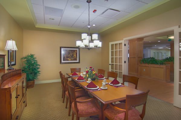 A formal dining room with a set table and elegant lighting.
