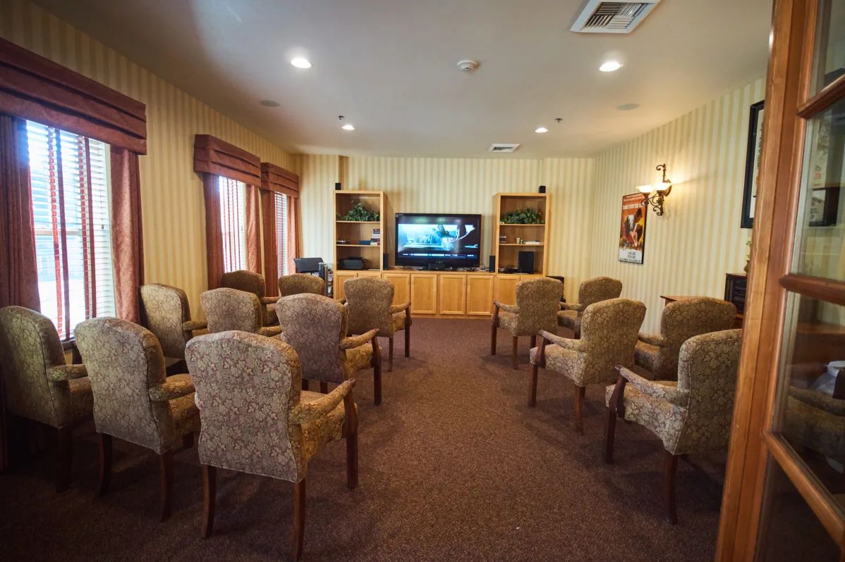 A cozy room with arranged seating facing a television for entertainment.