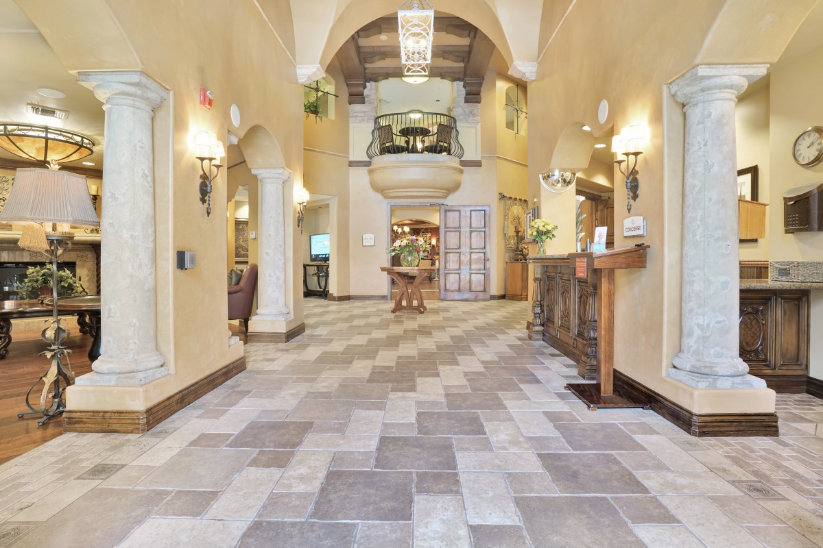 Elegant lobby with a vaulted ceiling and tile flooring.