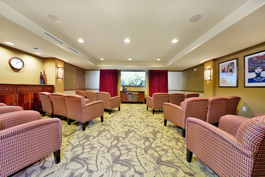 A cozy theater room with comfortable seating and a large projector screen.