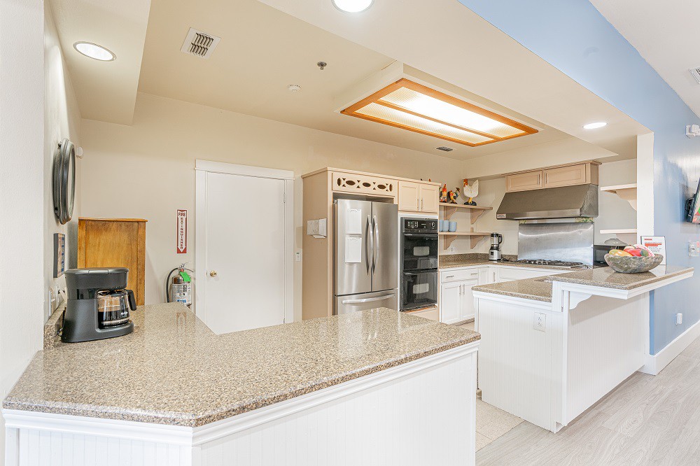 A modern kitchen with stainless steel appliances and a large countertop.