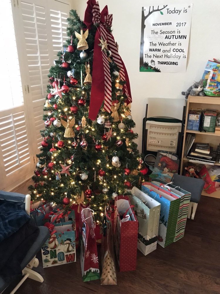 A beautifully decorated Christmas tree surrounded by gifts in a cozy living room setting.
