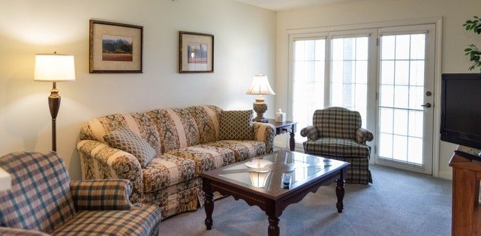 A cozy living room with patterned furniture and a wooden coffee table.