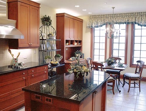 A spacious kitchen with wooden cabinets, granite countertops, and an adjoining dining area.