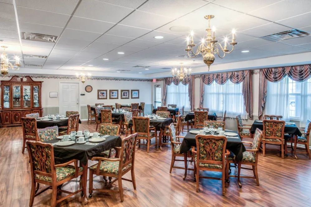 An elegant dining room with beautifully set tables and chandeliers.