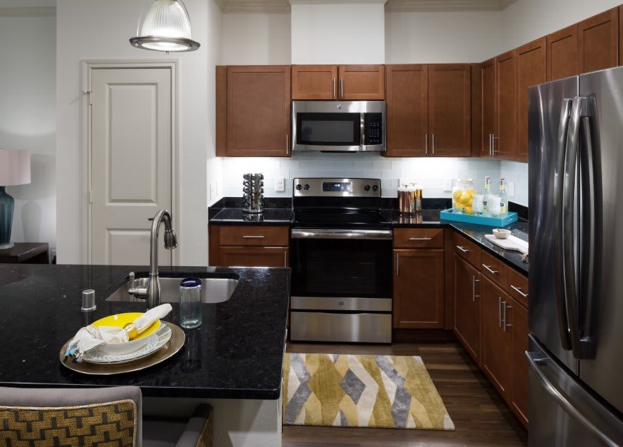 A modern kitchen featuring stainless steel appliances and wooden cabinetry.