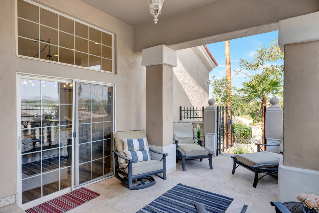 A cozy patio with comfortable chairs and colorful rugs, perfect for outdoor relaxation.