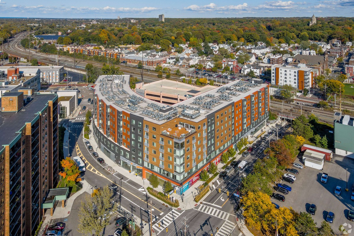 Aerial view of a large urban building situated at an intersection in a bustling commercial area.