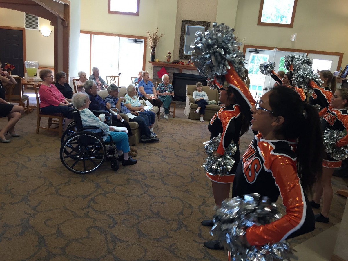 Cheerleaders perform for residents at a nursing home.